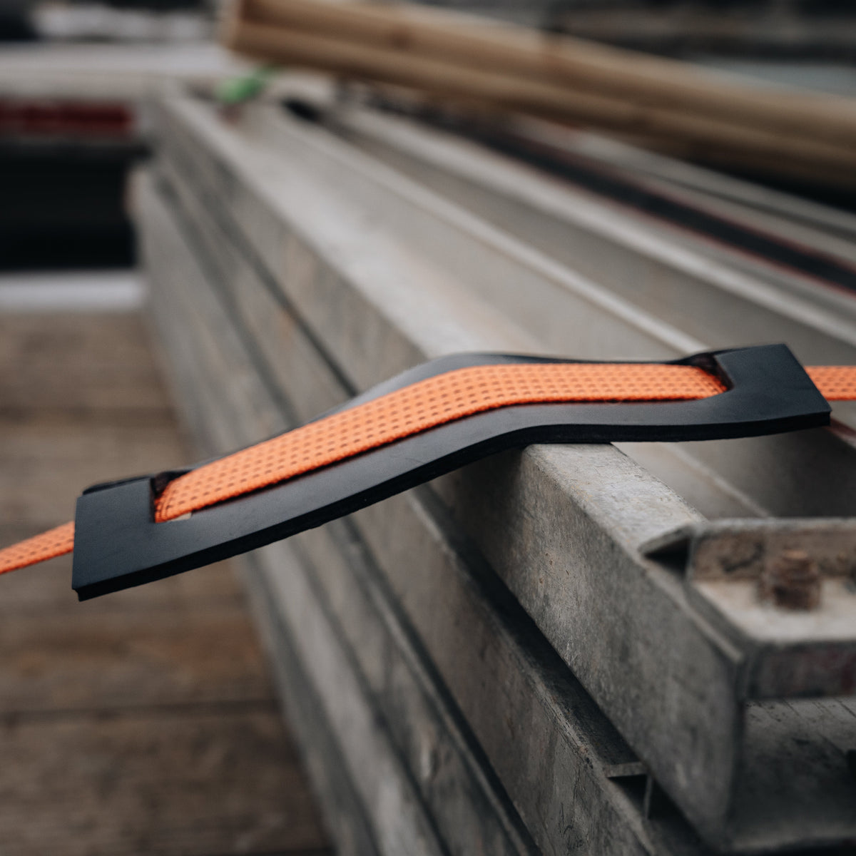 XL strap abrasion protector between orange webbing and a cargo edge